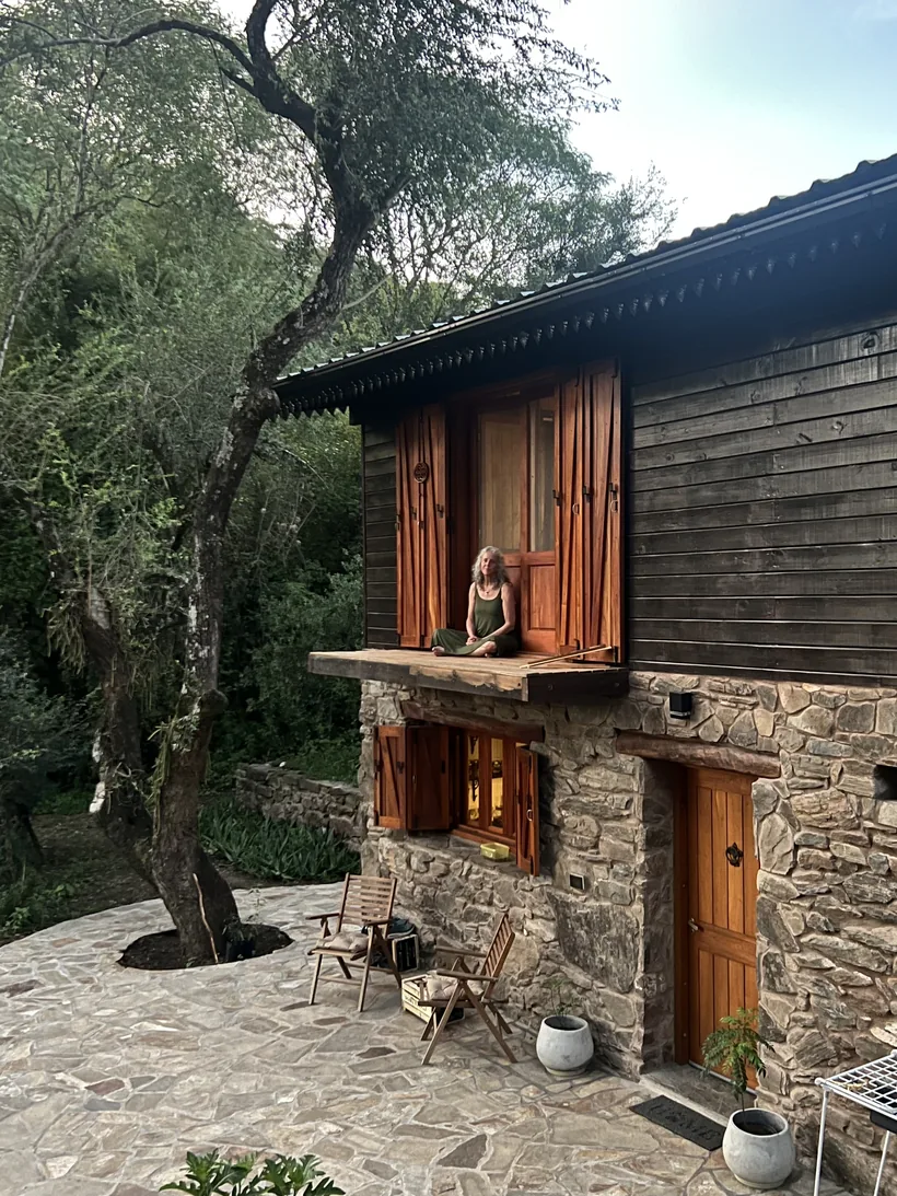 Casa de piedra y madera con balcón, entre los árboles del bosque