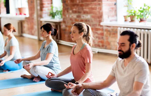 Grupo de personas meditando sentadas en una sala